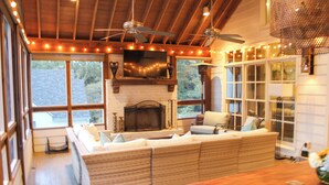 A cozy living room with a fireplace, large windows, and a wooden ceiling. - Walking Distance to Square and Campus, Spacious 5-Bedroom House (Oxford)
