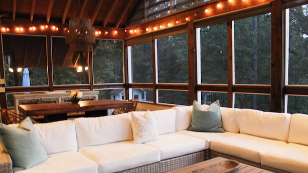 A cozy interior with a white sectional sofa, a wooden coffee table, and large windows offering a view of the forest. - Walking Distance to Square and Campus, Spacious 5-Bedroom House (Oxford)