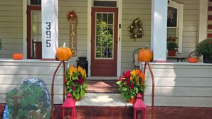 A porch with a red door, two potted plants, and a sign reading "Crawford."