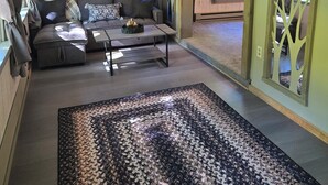 A cozy living room with a sofa, coffee table, and patterned rug.