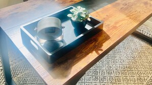 Una mesa de comedor con una bandeja, una planta y una cabeza de ciervo montada en la pared.