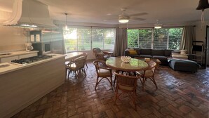A spacious living area with a kitchen, dining table, and seating.