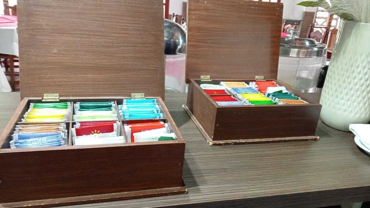 Zwei hölzerne Kisten mit zahlreichen Ordnern in verschiedenen Farben auf einem Tisch.