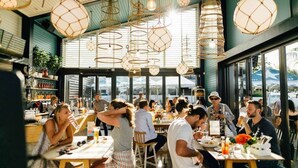 An indoor dining area with multiple tables and hanging light fixtures.