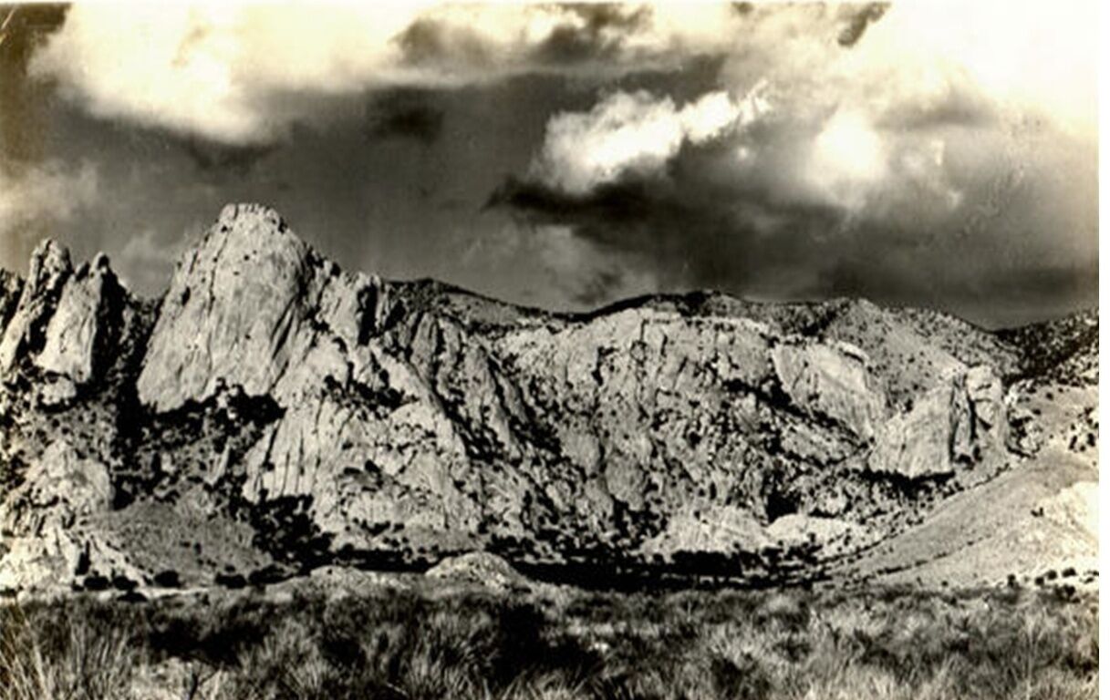 Un paisaje montañoso y agreste, con formaciones rocosas y vegetación escasa.