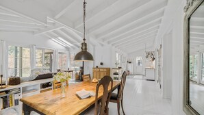 Un'ampia cucina con un tavolo in legno, sedie e un lampadario.