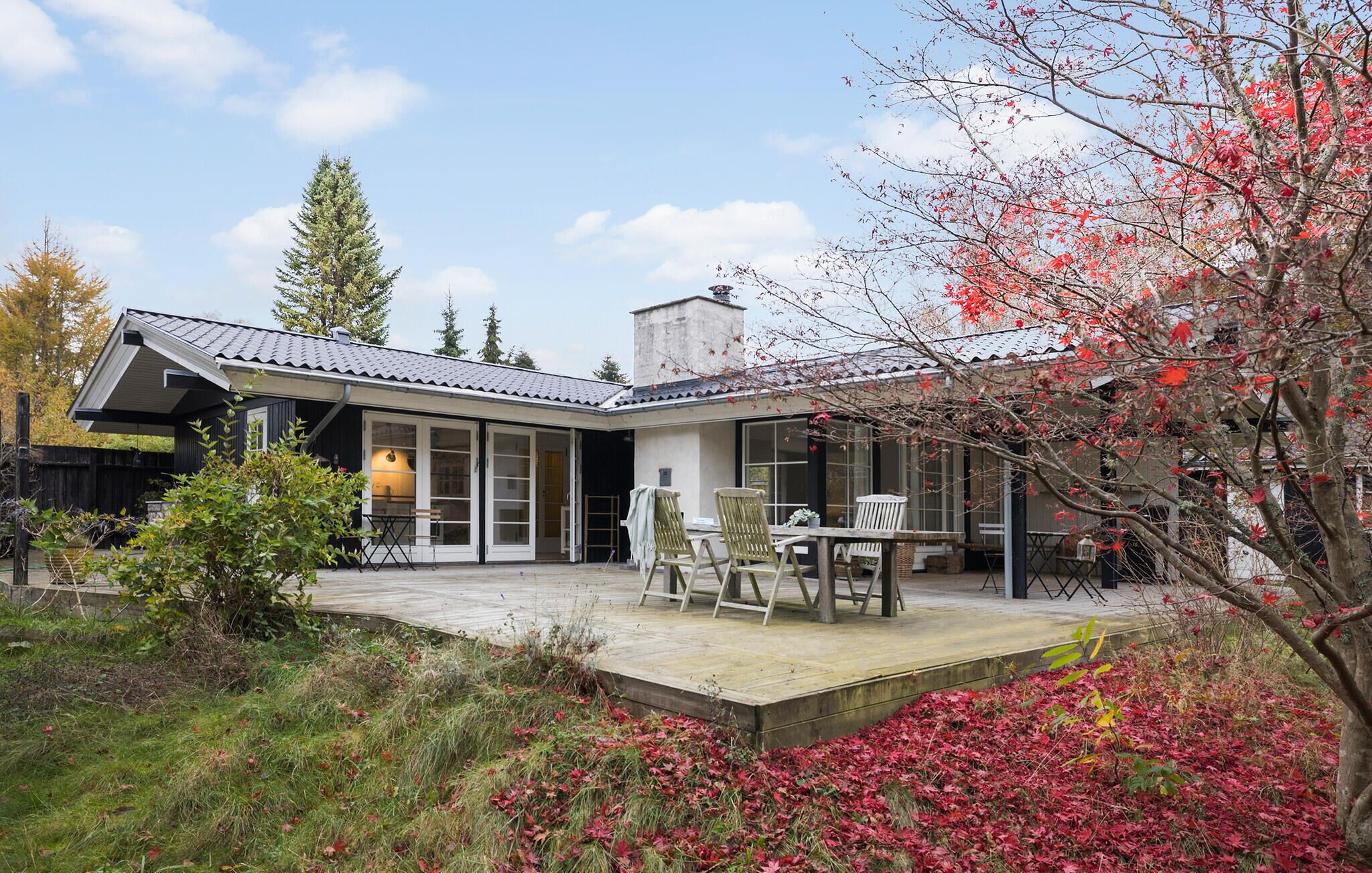 A modern house with a patio, a dining area, and a covered outdoor space.