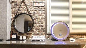 A bathroom vanity with a mirror, a DynaAir humidifier, and toiletries. - Hotel Louize (Seoul)