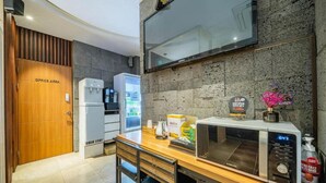 A compact office area with a wooden door labeled "OFFICE AREA," a refrigerator, a microwave, and a small table with a coffee maker and a box of coffee. - Hotel Louize (Seoul)