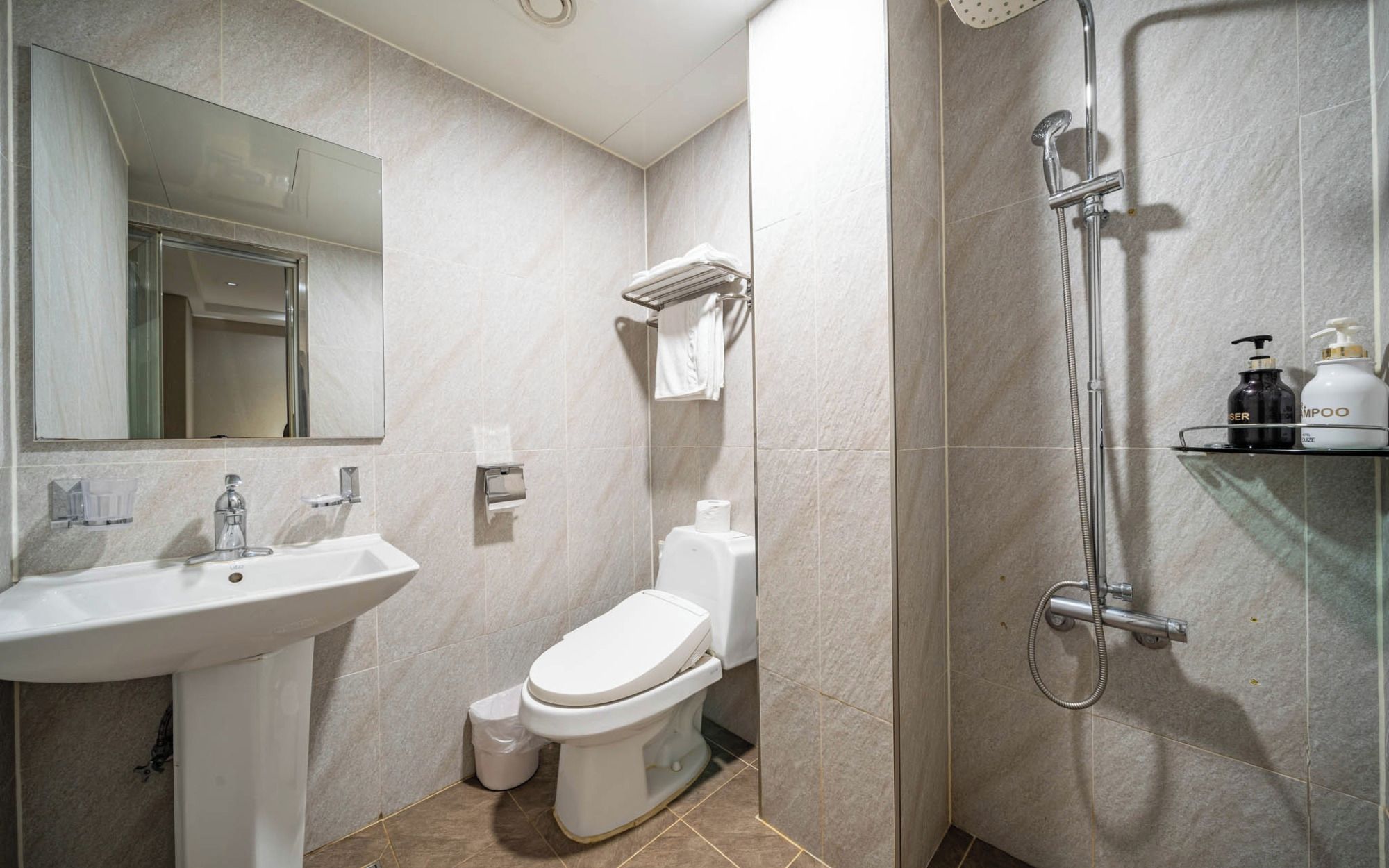 A modern bathroom with a sink, toilet, and shower.
