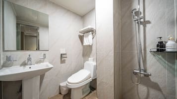 A modern bathroom with a sink, toilet, and shower.