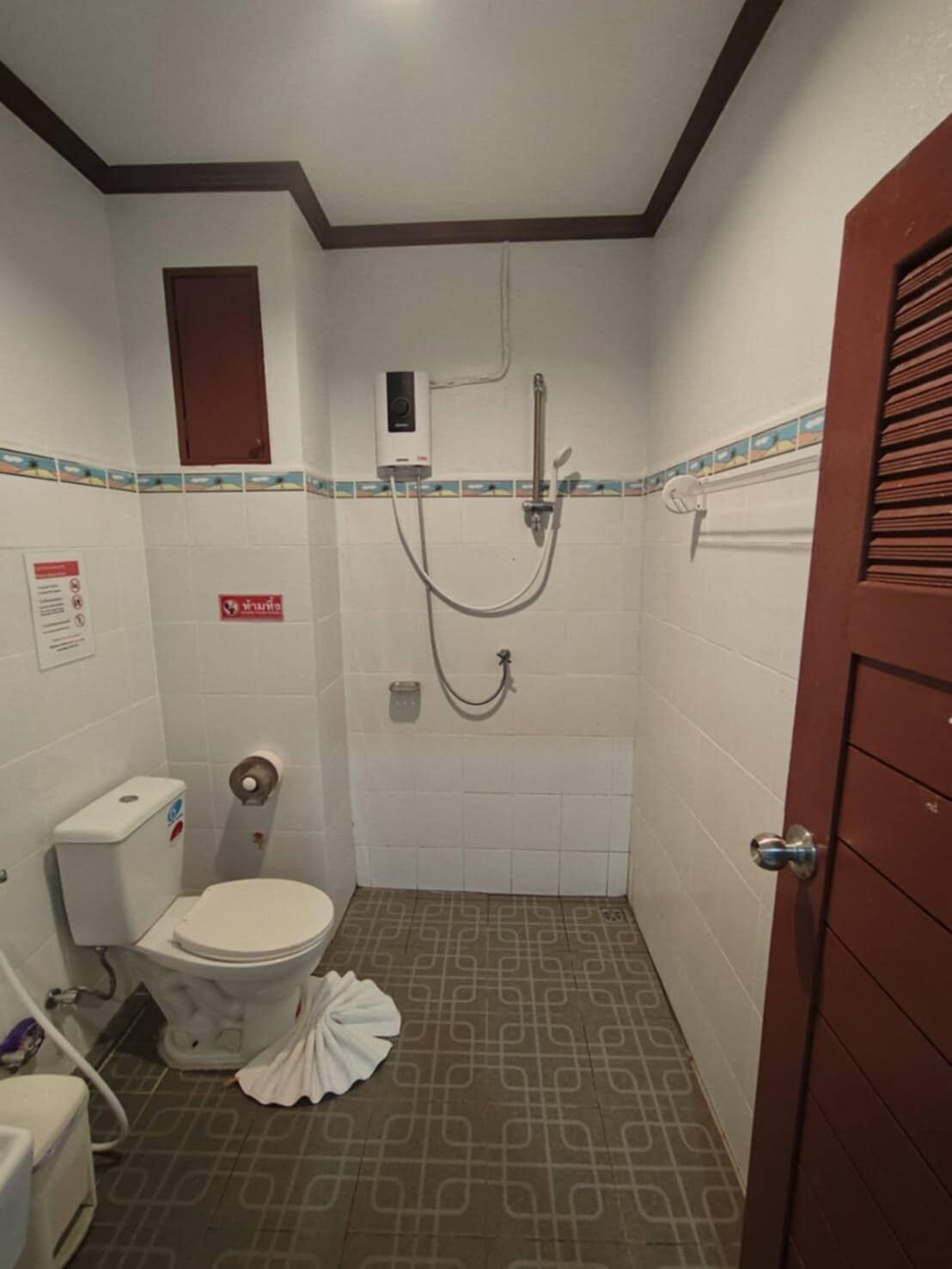 A small, compact bathroom with a toilet, bidet, and shower.