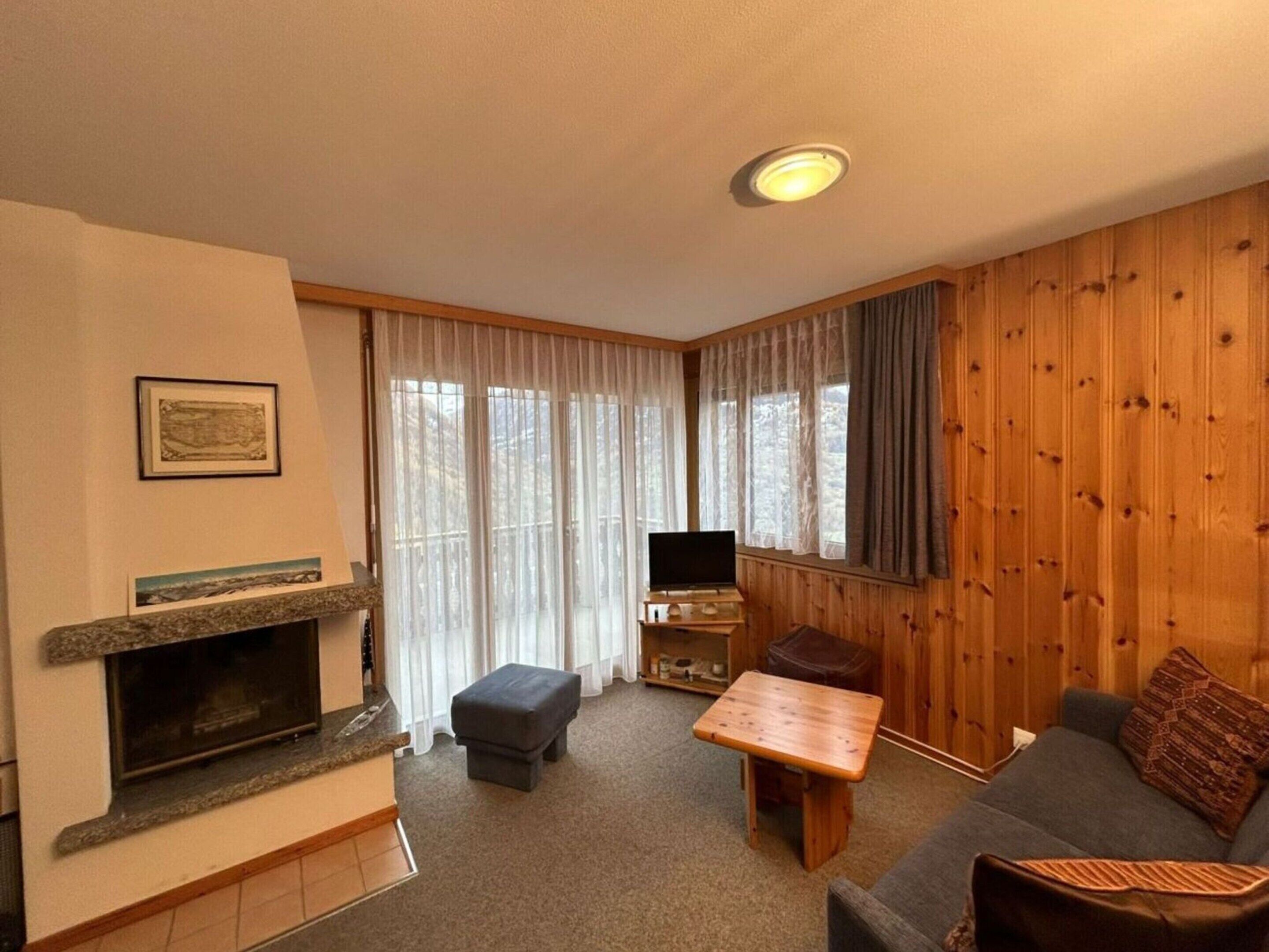 A cozy living room with a fireplace, a television, a sofa, and a coffee table.