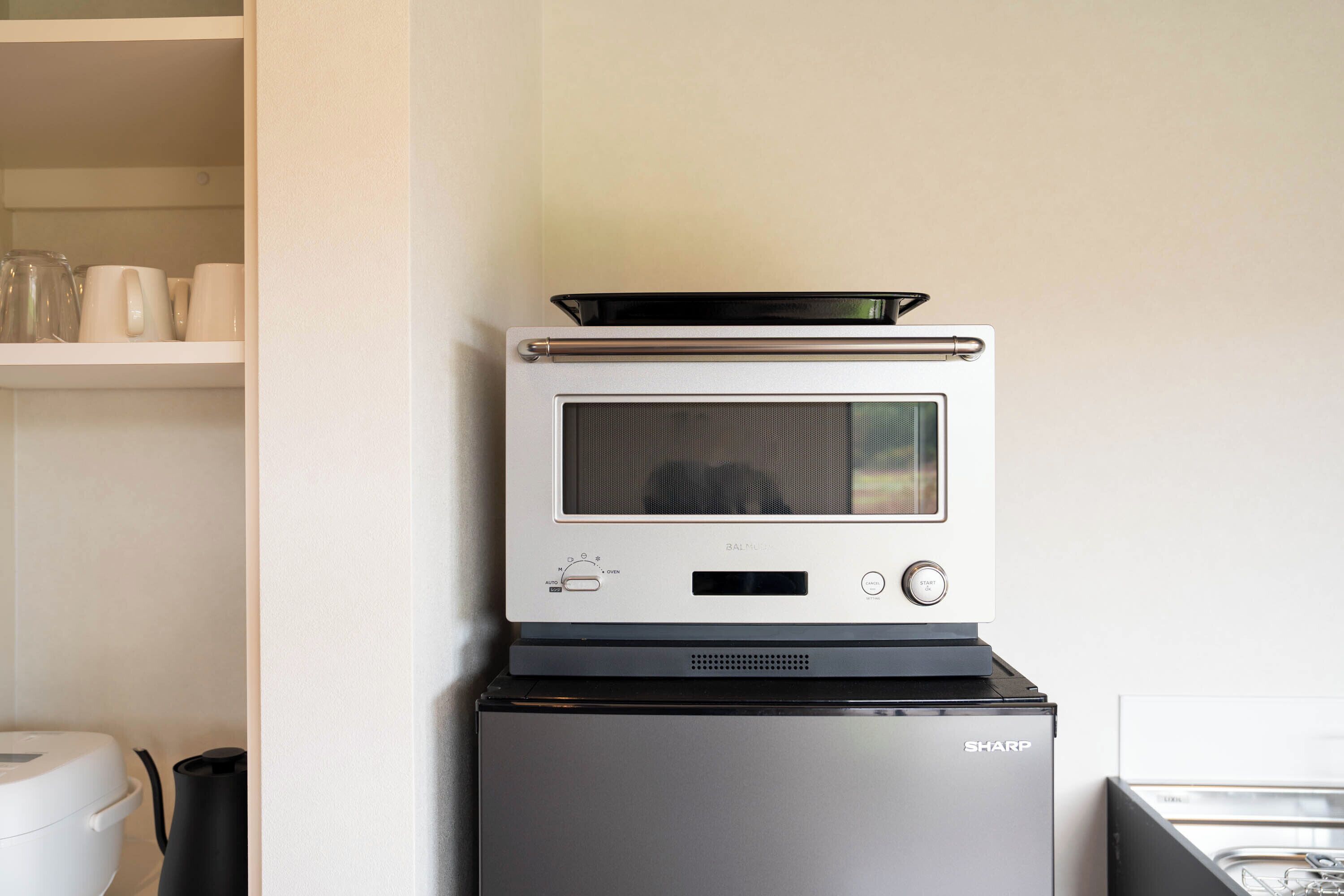 Une cuisine compacte équipée d’un four à micro-ondes et d’un petit réfrigérateur.