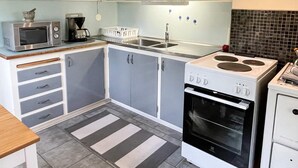 Una cocina moderna con gabinetes grises, una estufa blanca y un microondas.