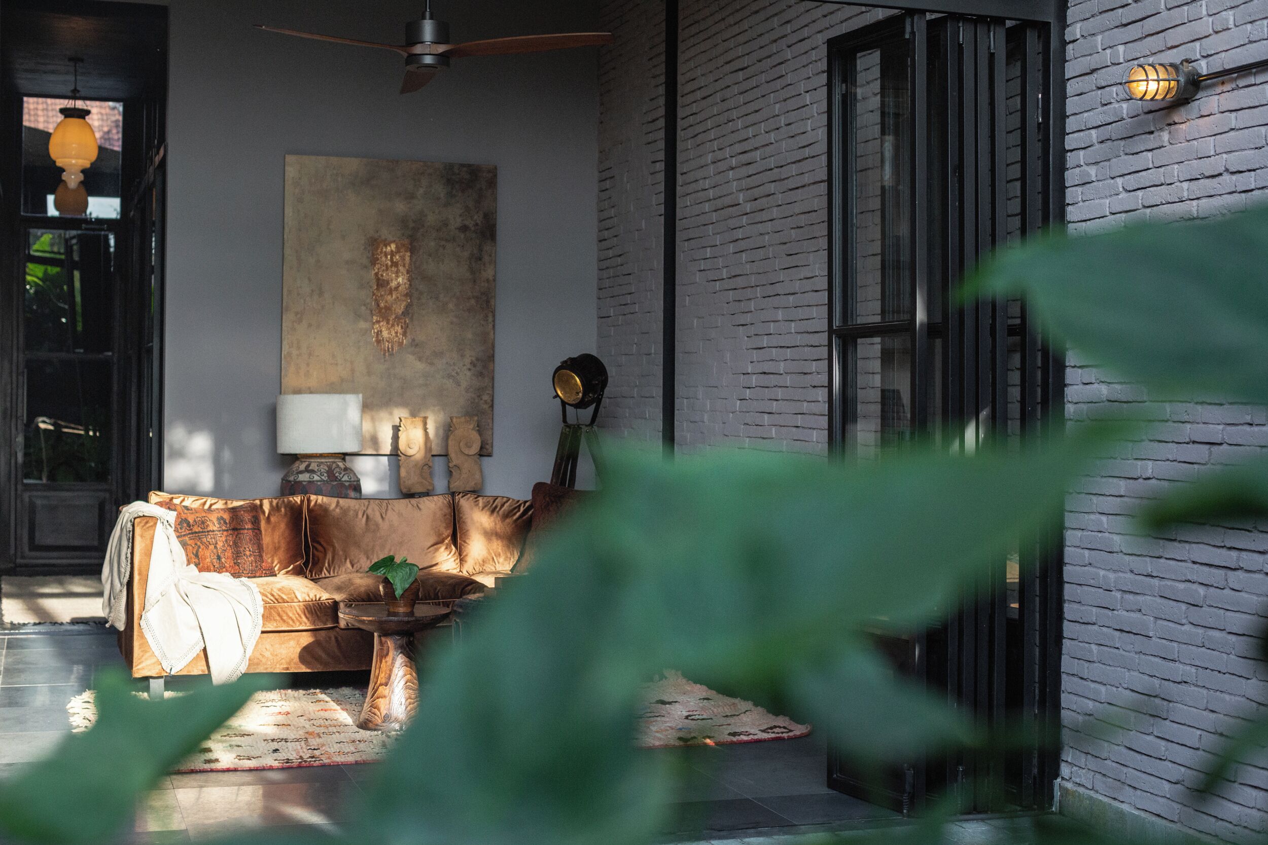A modern living room with a leather sofa, a coffee table, and a large abstract painting on the wall.