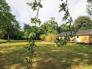 Un quartier résidentiel avec une maison, une pelouse verdoyante et des arbres.
