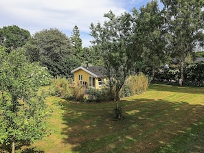 A small yellow house surrounded by trees and grass. - 6 Person Holiday Home in Borup (Borup)