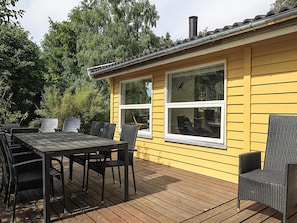 A yellow building with a deck, outdoor seating, and a chimney. - 6 Person Holiday Home in Borup (Borup)