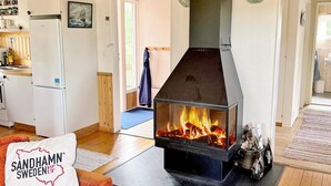 Un salon chaleureux avec une cheminée, un canapé et une table basse.