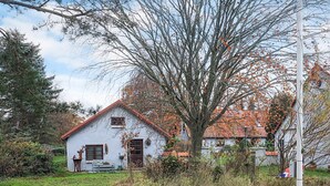 A white house with a red roof, surrounded by a garden and trees. - 5 Person Holiday Home in Saeby (Sæby)