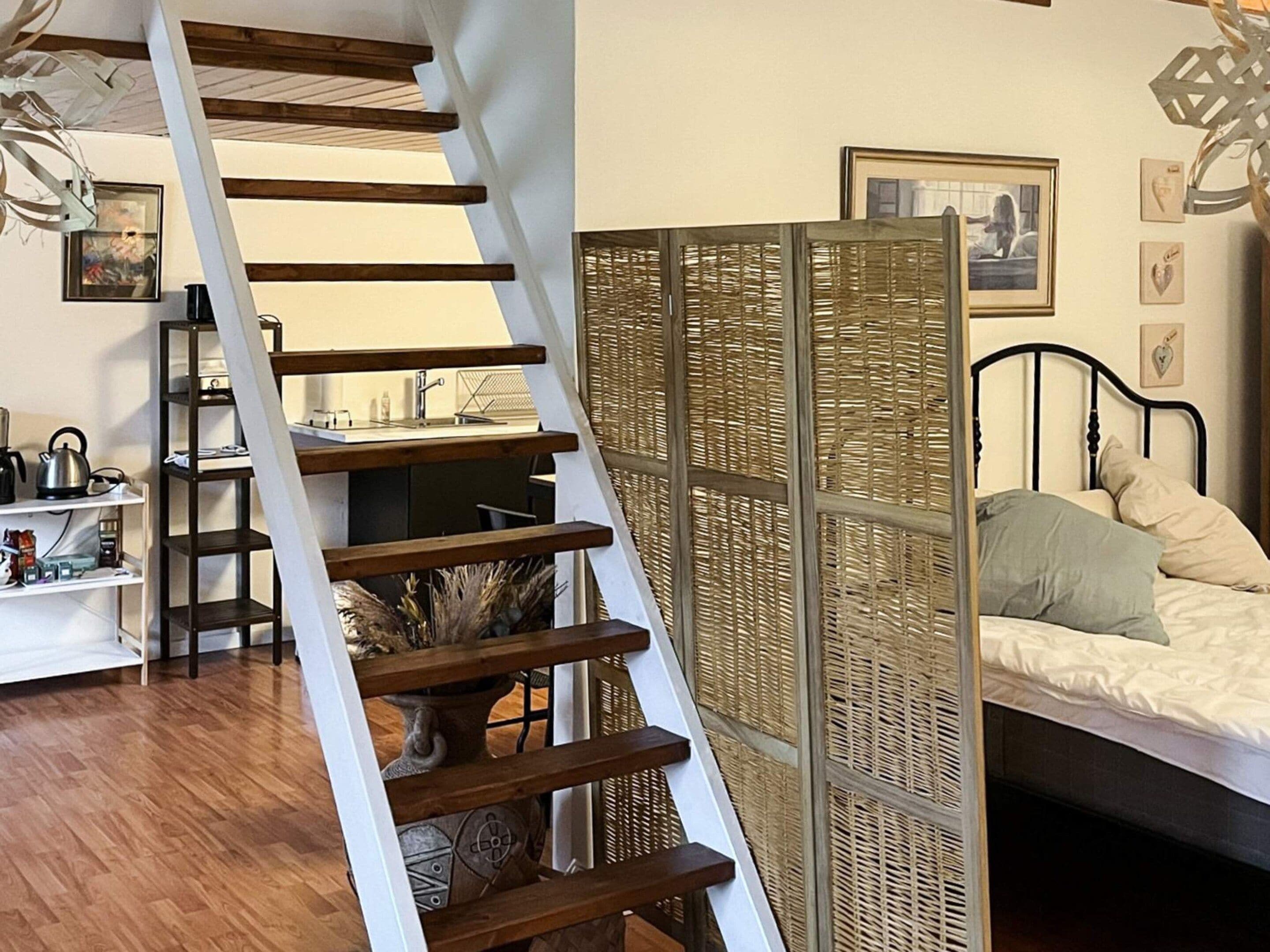 Un dormitorio con cama, mesita de noche, lámpara y un elemento decorativo en la pared.