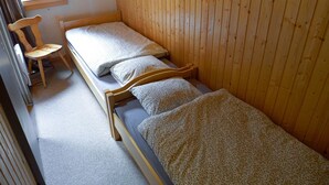 A small, single-room cabin with two wooden bunk beds, a wooden chair, and a window. - Apartment in Veysonnaz Near Ski Lift (Sion)