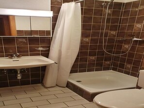 Un baño con ducha, inodoro y lavamanos.