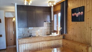 Eine Küche mit Holzausstattung, einer Steinrückwand, einer Holzbank und einem Tisch.