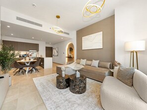A modern living room with a sofa, a dining table, and a coffee table.