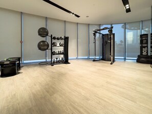 A spacious gym with a pull-up bar, kettlebells, and a punching bag.