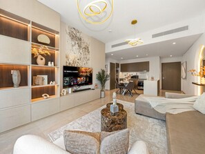 A modern living room with a flat-screen TV, a coffee table, and a sofa.
