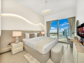 Een moderne hotelkamer met een groot bed, nachtkastjes, een bureau en een televisie.
