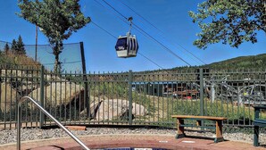 A swimming pool with a cable car in the background.