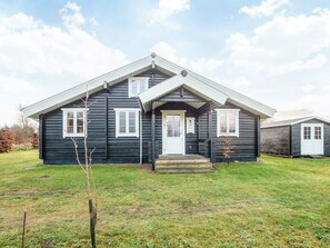 A two-story wooden house with a front porch and a small front yard. - 4 Star Holiday Home in Hovborg (Hovborg)