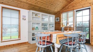 A wooden interior with a dining table, chairs, and a white cabinet with glass doors. - 4 Star Holiday Home in Hovborg (Hovborg)