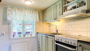 A kitchen with a window, a stove, and a sink. - 5 Person Holiday Home in Borgholm (Borgholm)