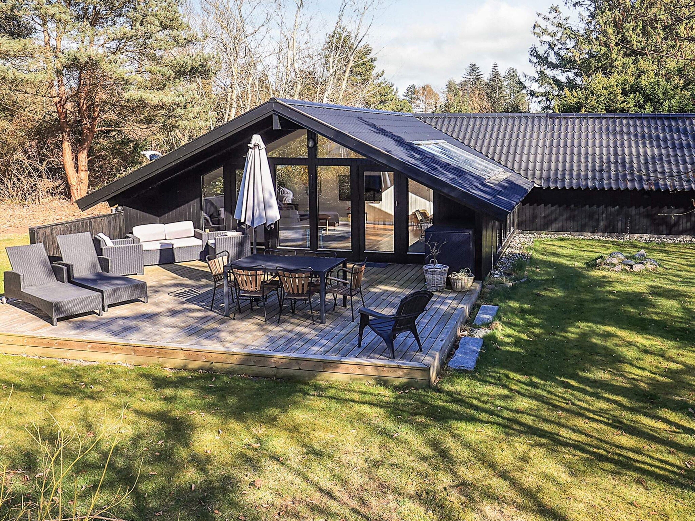 A modern outdoor patio with a dining area, seating, and a covered section.