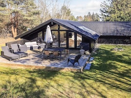 A modern outdoor patio with a dining area, seating, and a covered section.