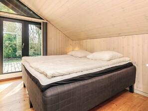 A bedroom with a bed, a window, and a view of greenery. - 4 Star Holiday Home in Vaeggerlose (Vaeggerlose)