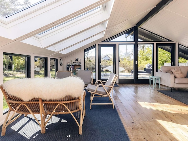A spacious room with a high ceiling, large windows, and a view of the outdoors. - 4 Star Holiday Home in Vaeggerlose (Vaeggerlose)