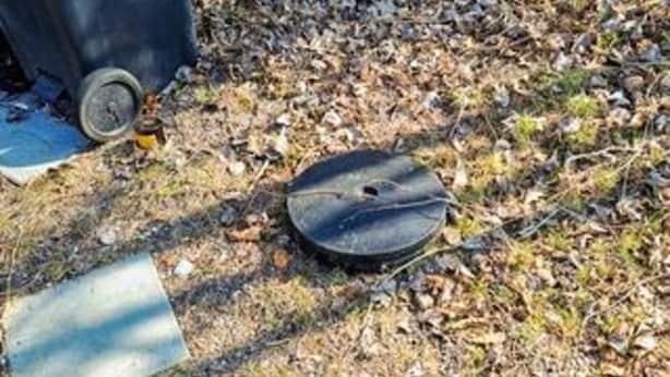 A round, dark-colored object on the ground with a small hole, surrounded by dry leaves and a piece of blue fabric. - 4 Star Holiday Home in Vaeggerlose (Vaeggerlose)