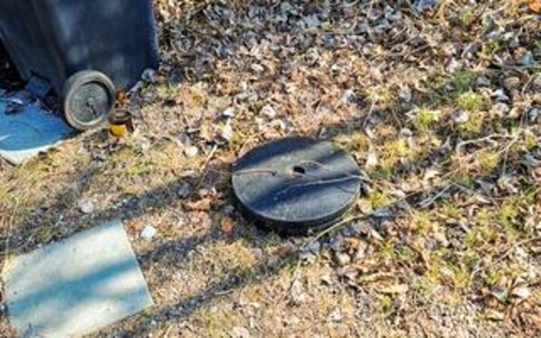 A round, dark-colored object on the ground with a small hole, surrounded by dry leaves and a piece of blue fabric. - 4 Star Holiday Home in Vaeggerlose (Vaeggerlose)