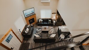 A modern living room with a fireplace, a sofa set, a coffee table, and a TV mounted on the wall.