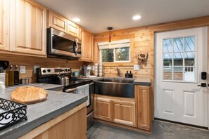 A kitchen with wooden cabinets, stainless steel appliances, and a large window.