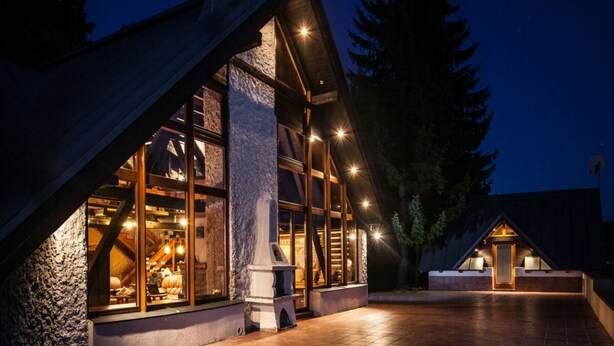 A modern lodge with a stone facade, large windows, and a well-lit entrance. - Comfortable Villa With Facilities (Benecko)