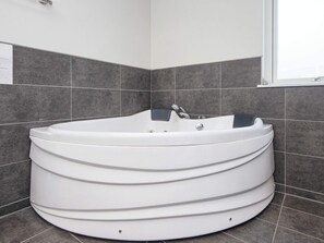 A modern bathroom with a freestanding bathtub, grey tiles, and a window. - 4 Star Holiday Home in Sydals (Sydals)