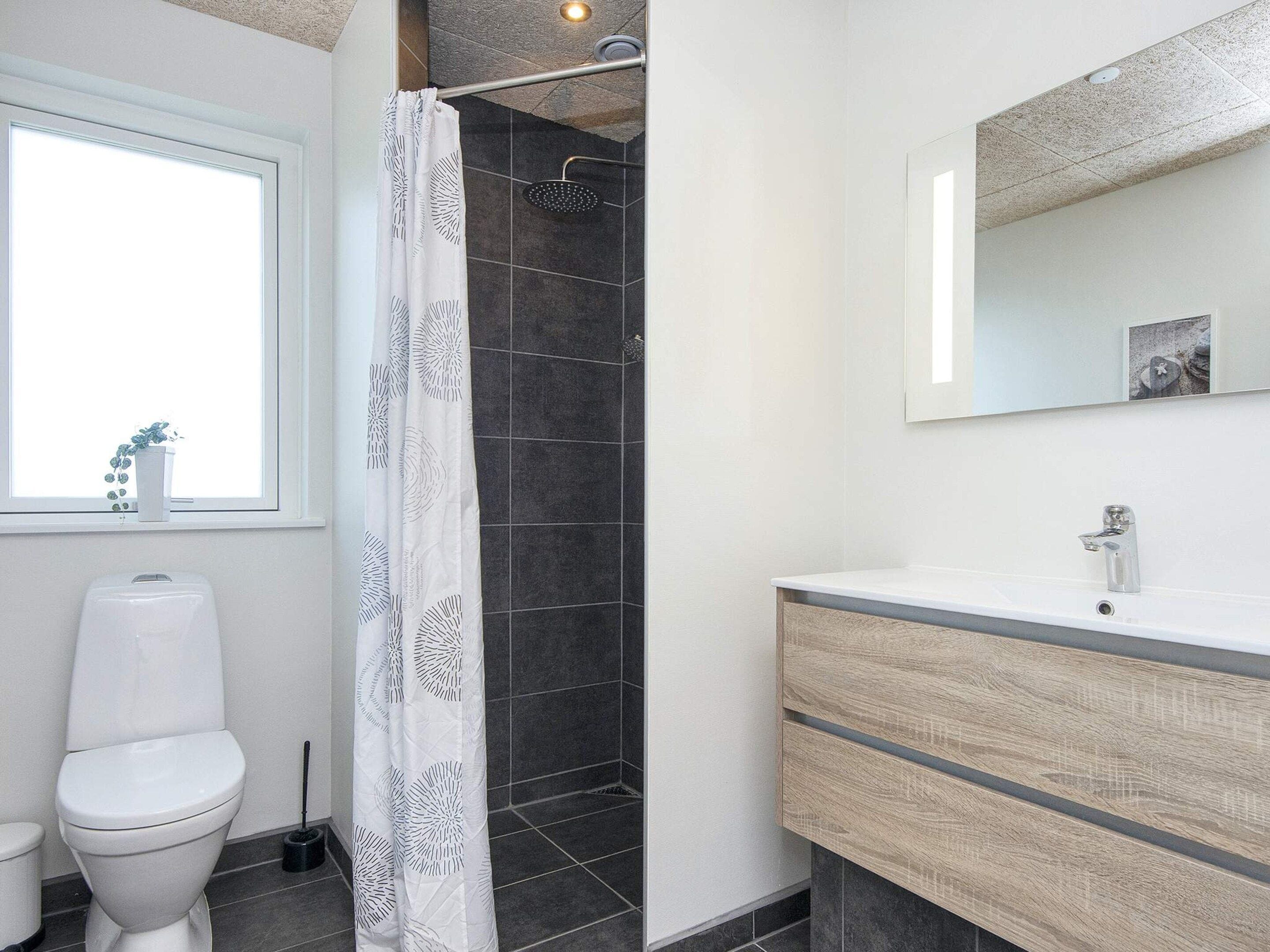 Une salle de bain avec des toilettes, une douche et un lavabo.