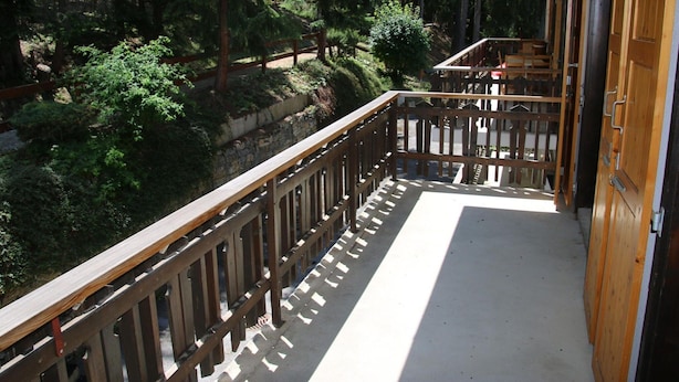 A balcony with a wooden railing overlooking a forested area. - Mystical Apartment With Mountain Views (Veysonnaz)