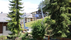 A residential area with houses, a car, and a ski lift. - Mystical Apartment With Mountain Views (Veysonnaz)